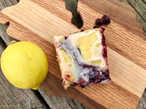 Lemony Blueberry Bars -- Rich, gooey, yummy blueberry filling ribboned into a cake that's so decadent it passes even through these lips that hate cake. Add the lemony glaze that reminds me of lemon pound cake and you have dessert perfection. | thatwhichnourishes.com