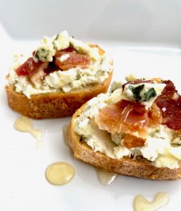 Gorgonzola Bacon Crostinis -- Crispy, seasoned and toasted baguette slices schmeared with a flavorful bleu cheese and cream cheese combination, topped with salty bacon, and drizzled with honey. | thatwhichnourishes.com